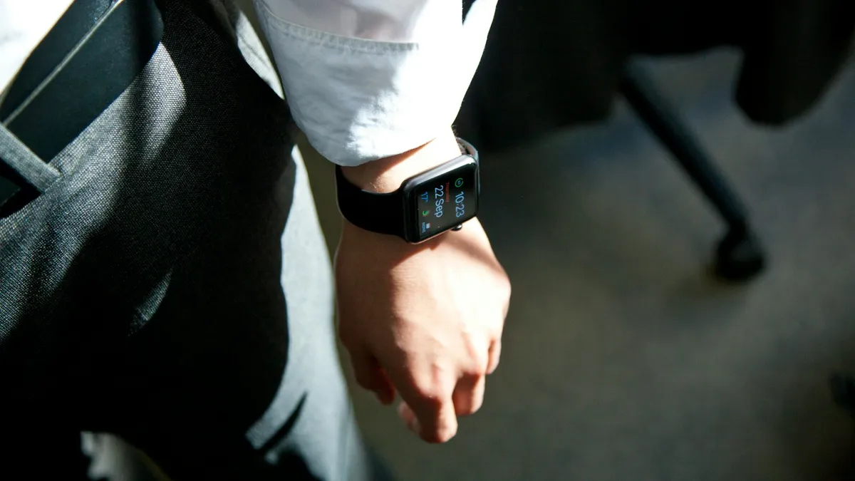 An Apple Watch on a person's wrist in a sunlit office