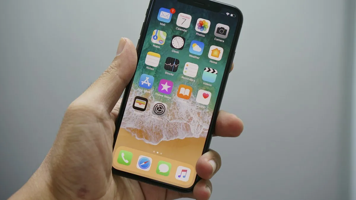 A hand holding a smartphone that shows a home screen with app icons