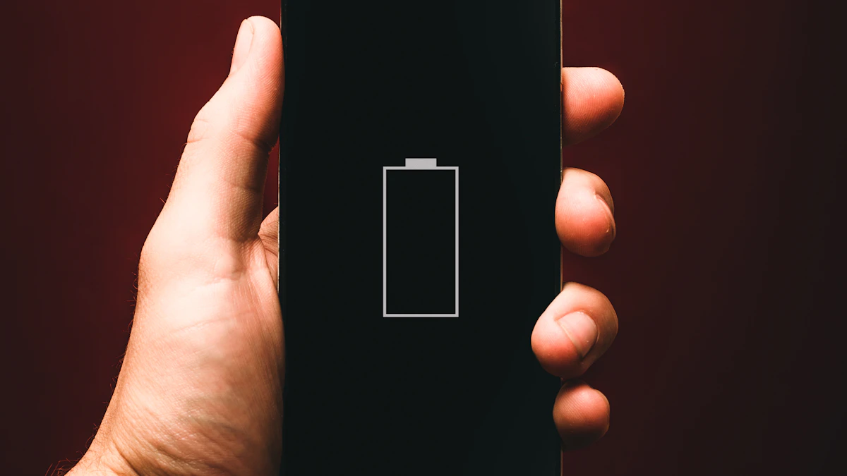 A hand holding a phone showing an empty battery icon